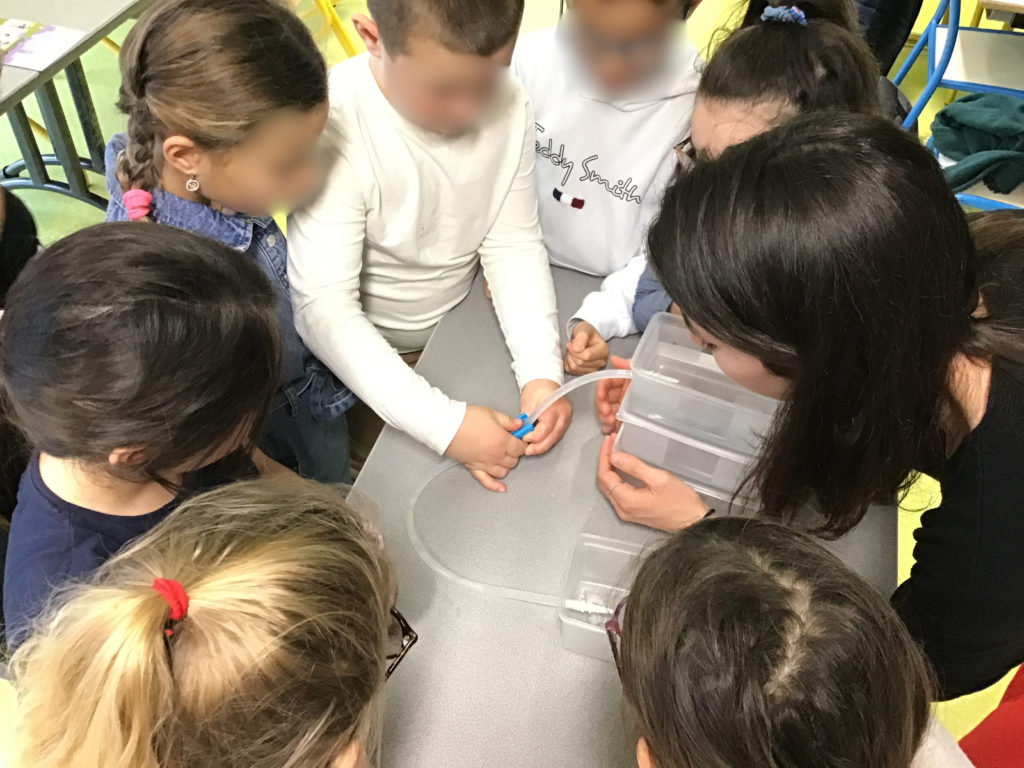 Photo de l'animation scolaire sur l'eau à l'école d'Albon. Les élèves participent à l'expérience sur le fonctionnement d'un château d'eau.