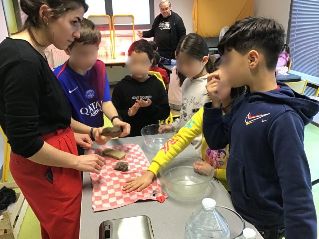 Photo de l'animation scolaire sur l'eau à l'école d'Albon. Les élèves participent à l'expérience sur le fonctionnement d'une nappe souterraine.